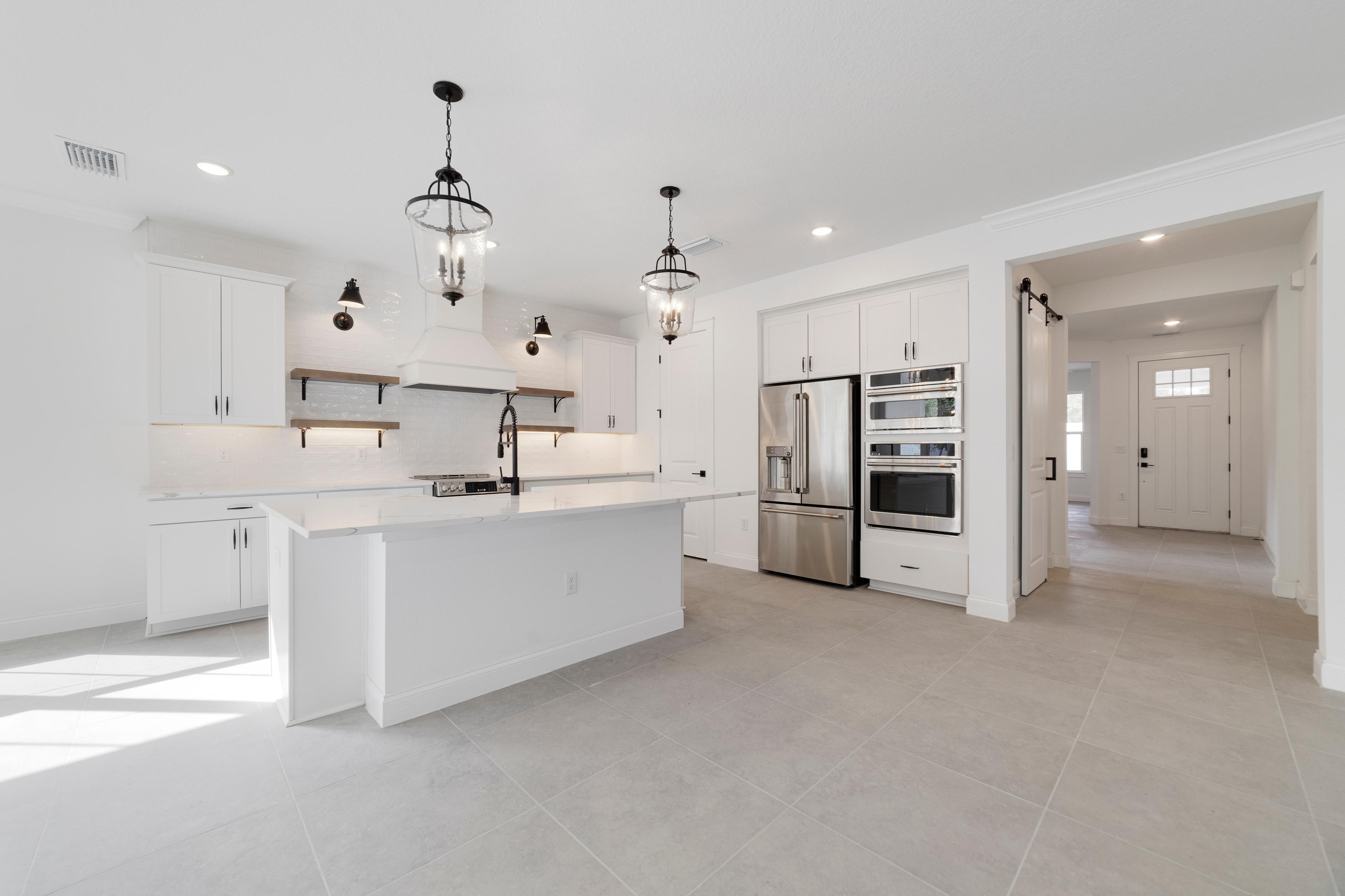 Kitchen with floating shelves and pendant lights