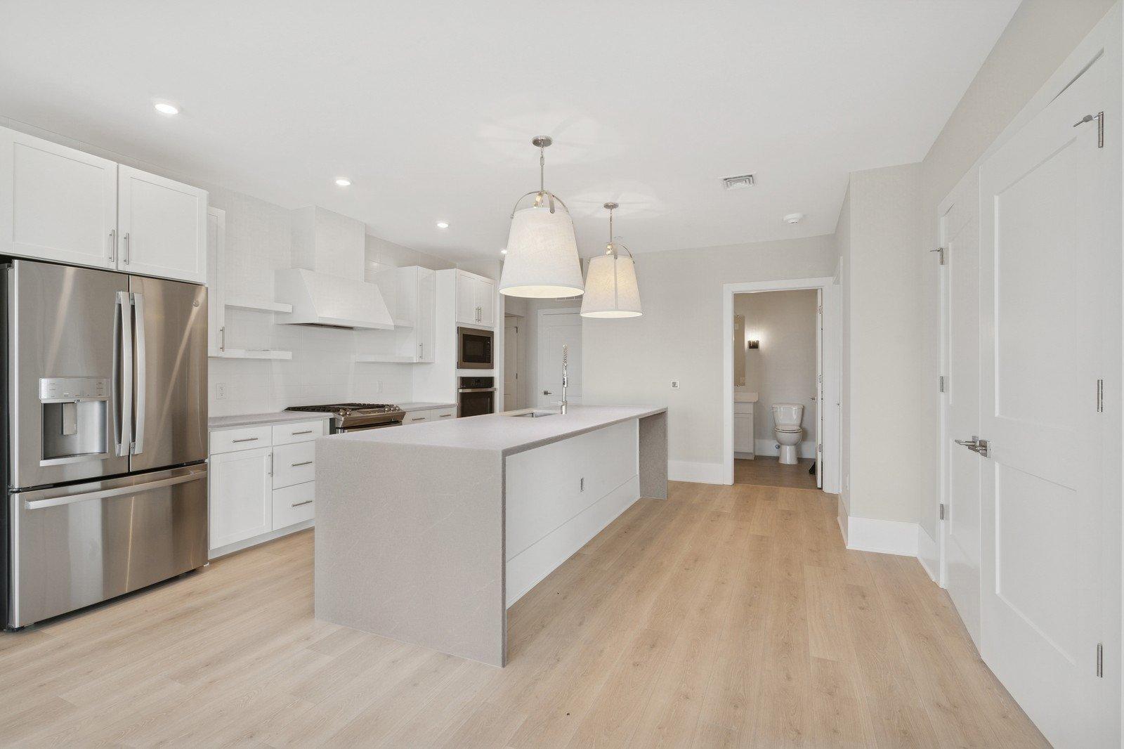 Kitchen featuring waterfall island & floating shelves